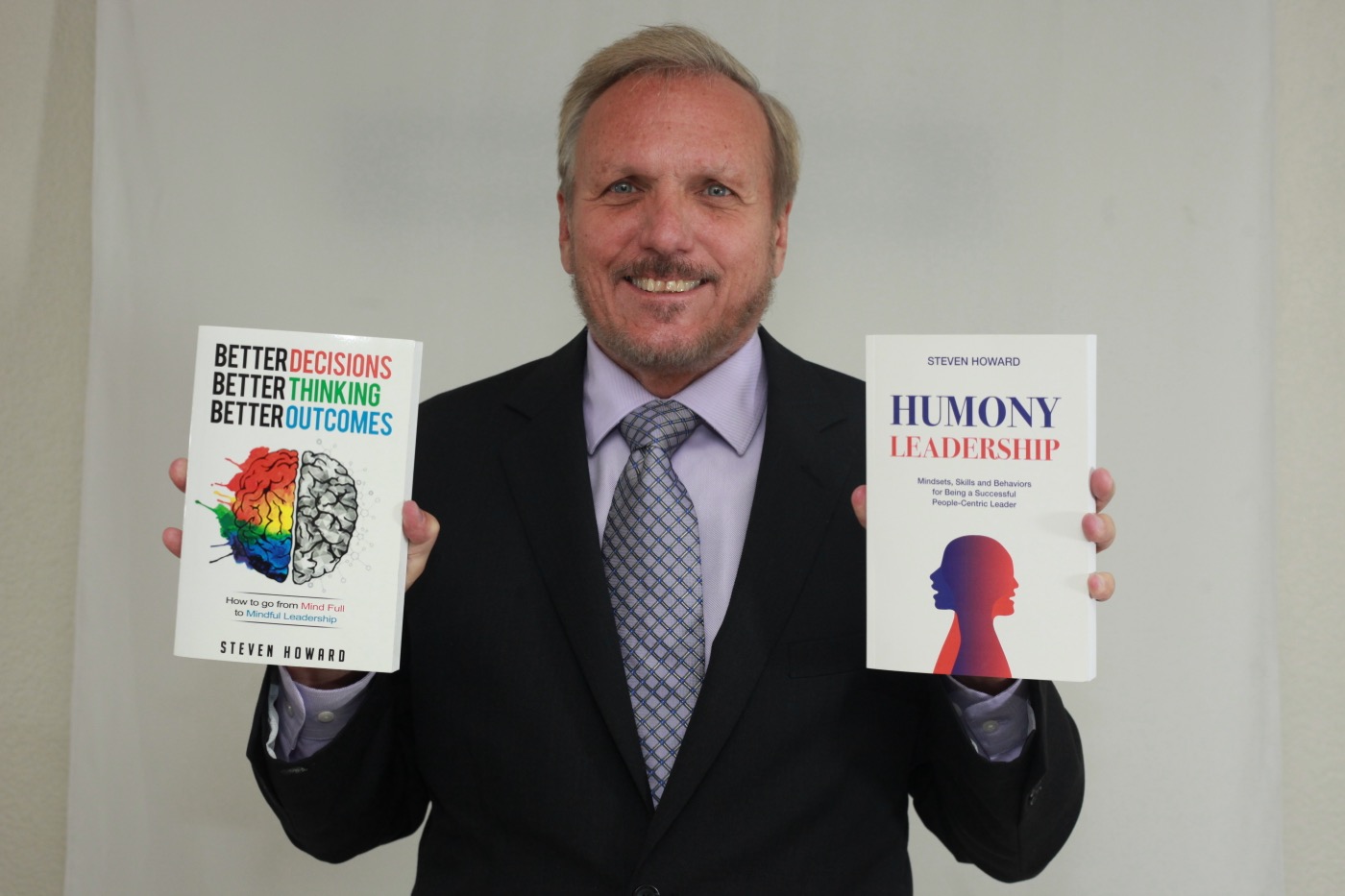 Steven Howard holding two of his books